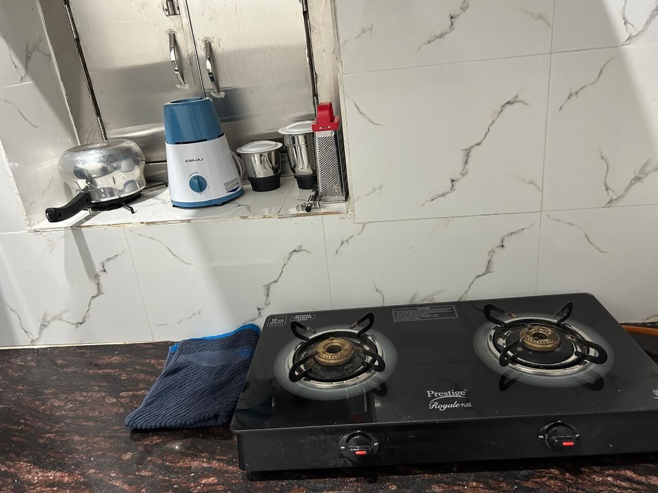 Uma cozinha com fogão a gás, chaleira e máquina de café.
