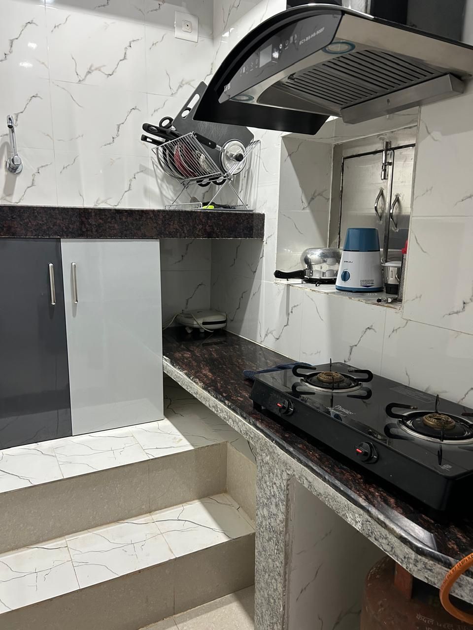 A kitchen with a gas stove, a microwave, and a coffee maker on the countertop.
