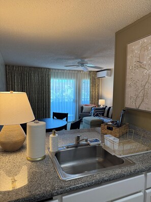 Una habitación de hotel con kitchenette, zona de comedor y sala de estar.