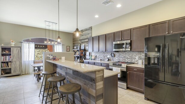 A modern kitchen with a central island, bar stools, stainless steel appliances, and a farmhouse-style dining area. - Dog Friendly Tucson 3bd 2.5ba Family Home Snowbirds Pool Access Fire Pit Grill (Tucson)