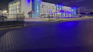 A modern building with large windows and a blue-lit facade.
