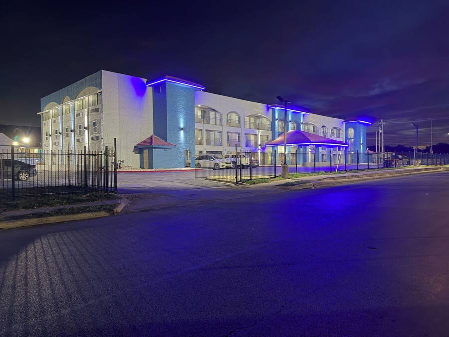 A modern building with large windows and a blue-lit facade.