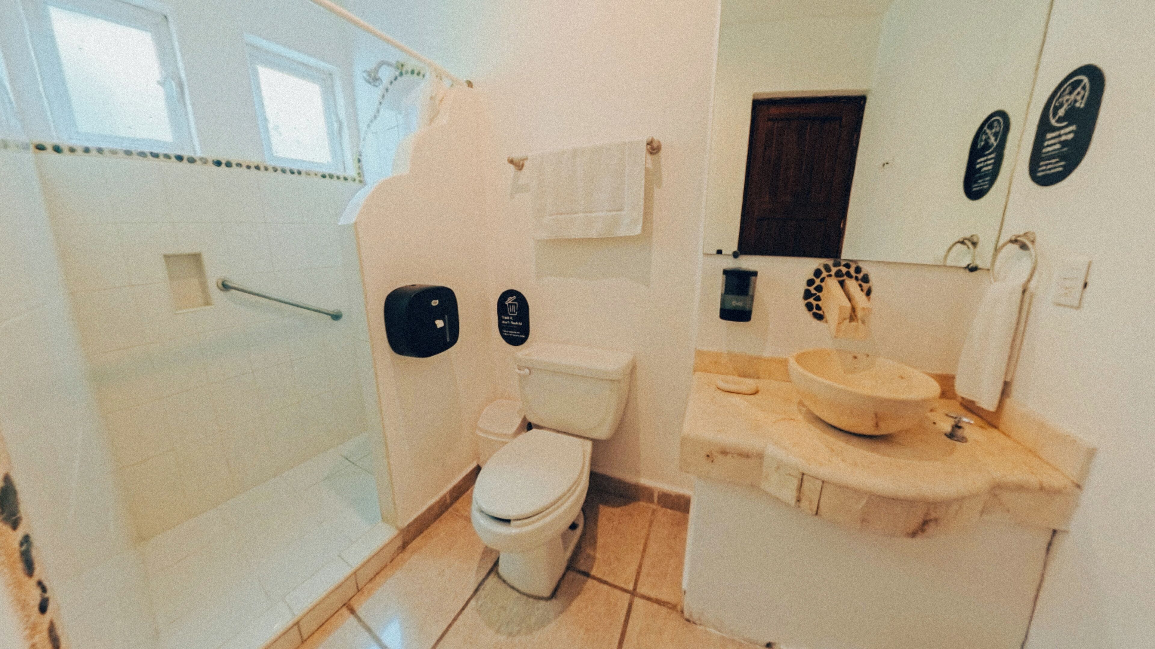 A bathroom with a toilet, sink, and shower.