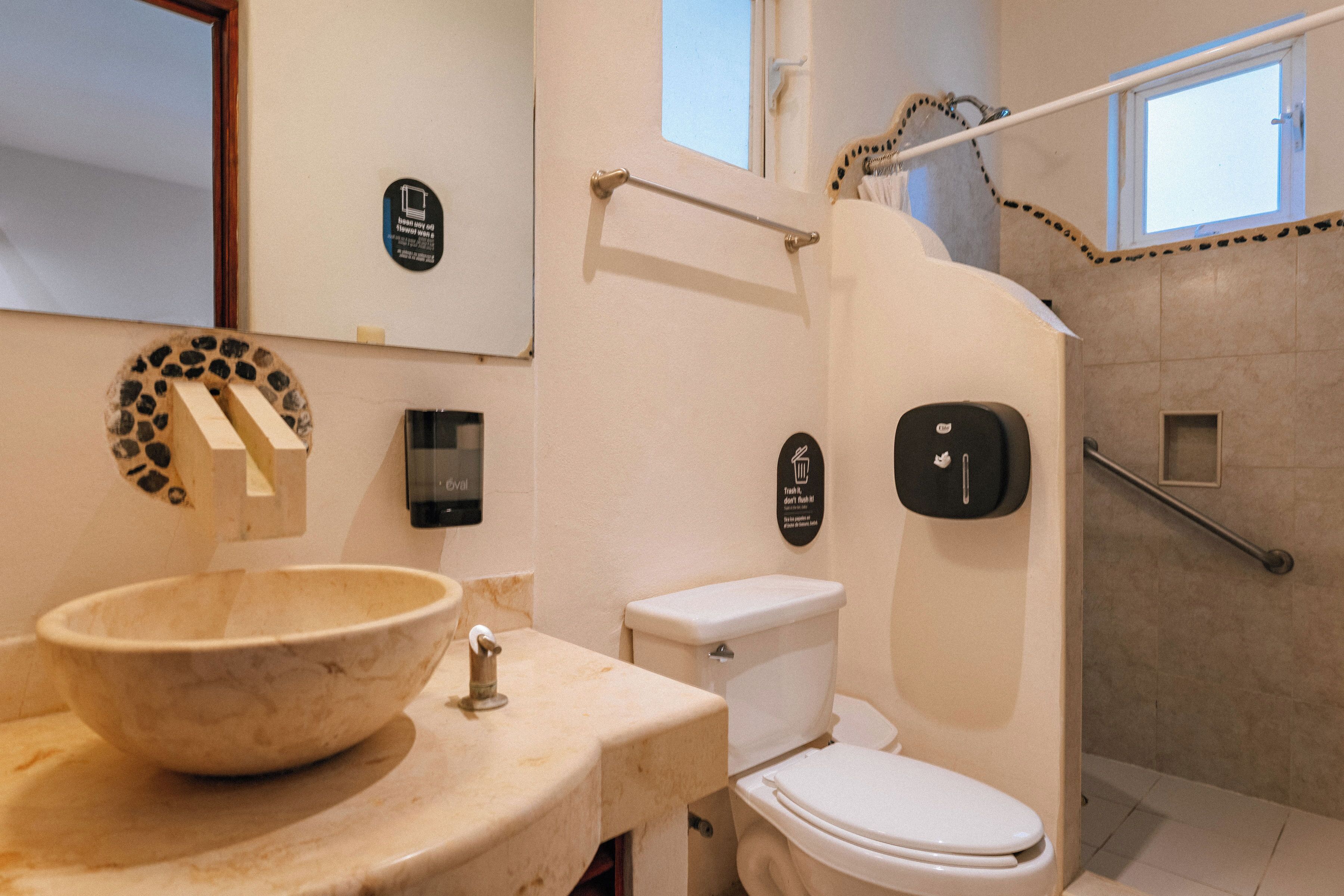 A bathroom with a marble sink, toilet, and a shower area.