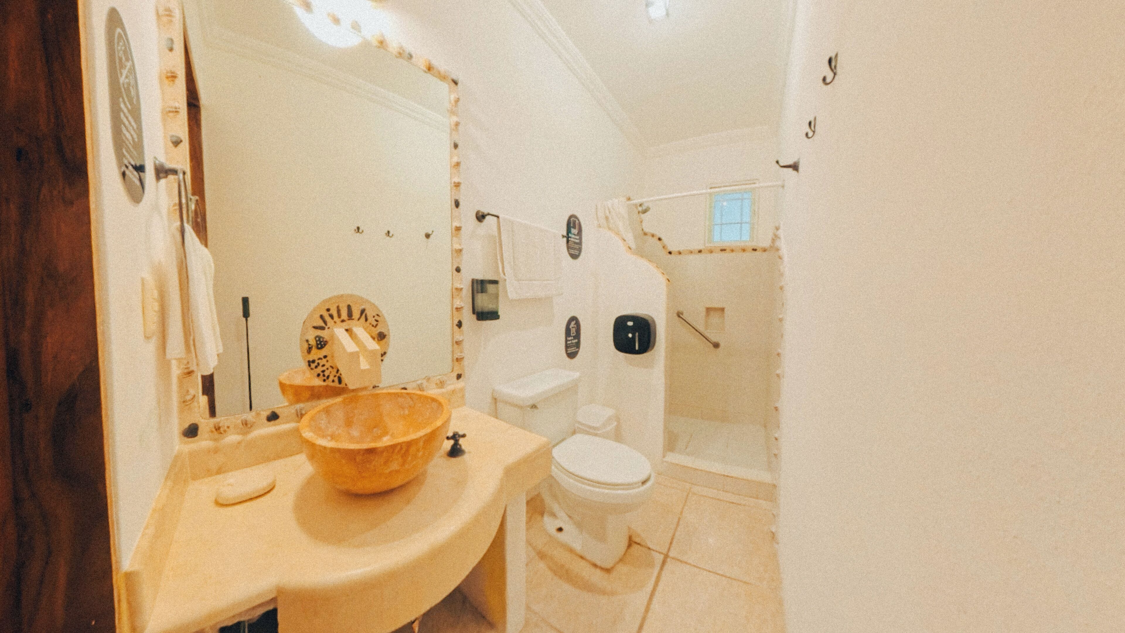 A bathroom with a sink, mirror, toilet, and shower area.