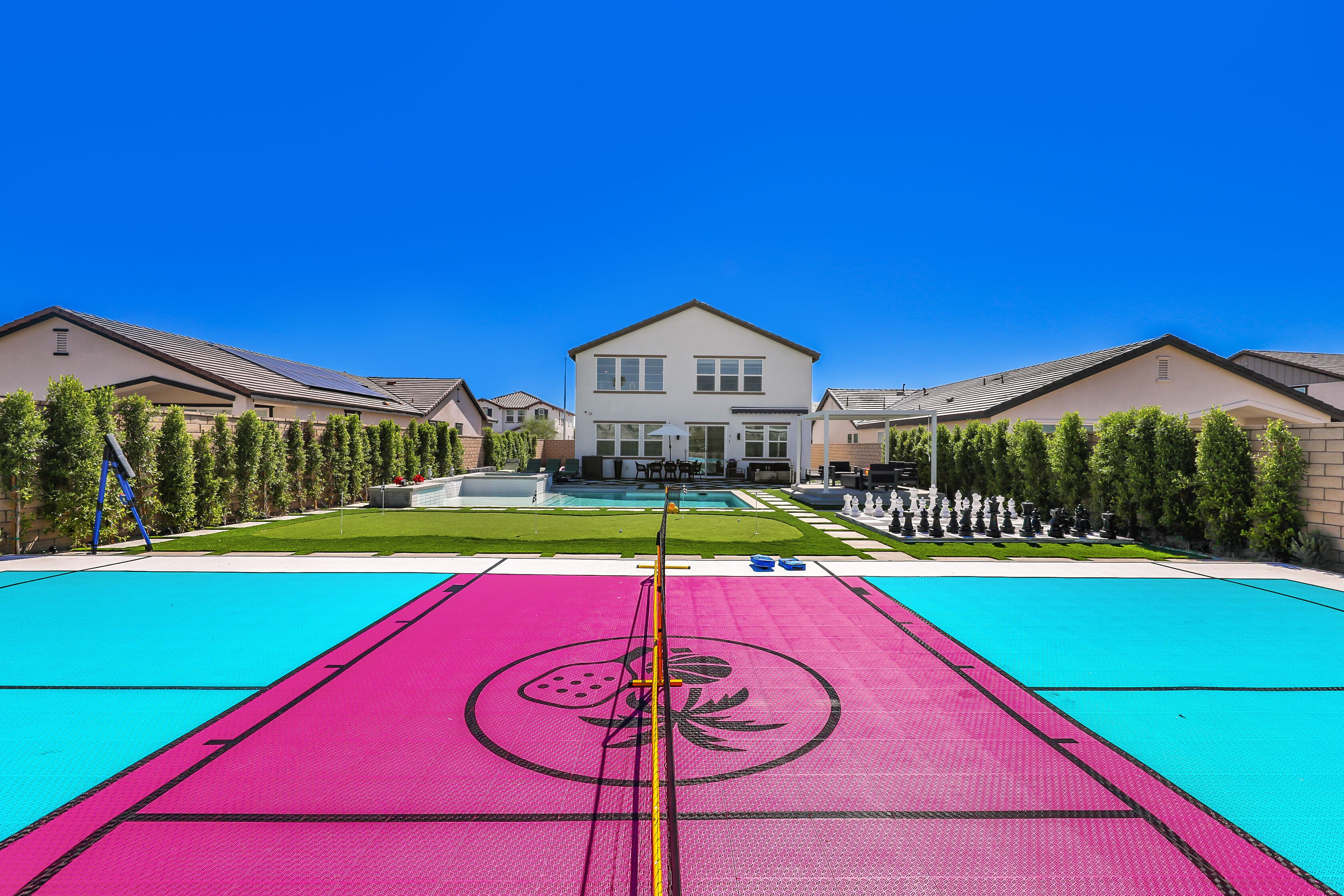 A residential area with a large house, a swimming pool, and a tennis court.