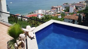 A pool with a view of a coastal cityscape. -  Penthouse suite with dipping pool, palapa & private sunroof overlooking the Bay (Puerto Vallarta)