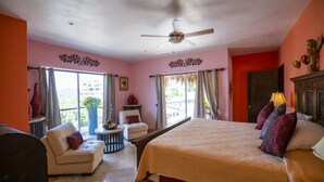 A hotel room with a bed, a chair, a small table, and a ceiling fan. -  Penthouse suite with dipping pool, palapa & private sunroof overlooking the Bay (Puerto Vallarta)