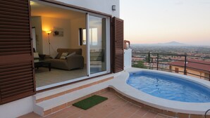 Een balkon met een zwembad, een bank en een schuifdeur naar een woonruimte.