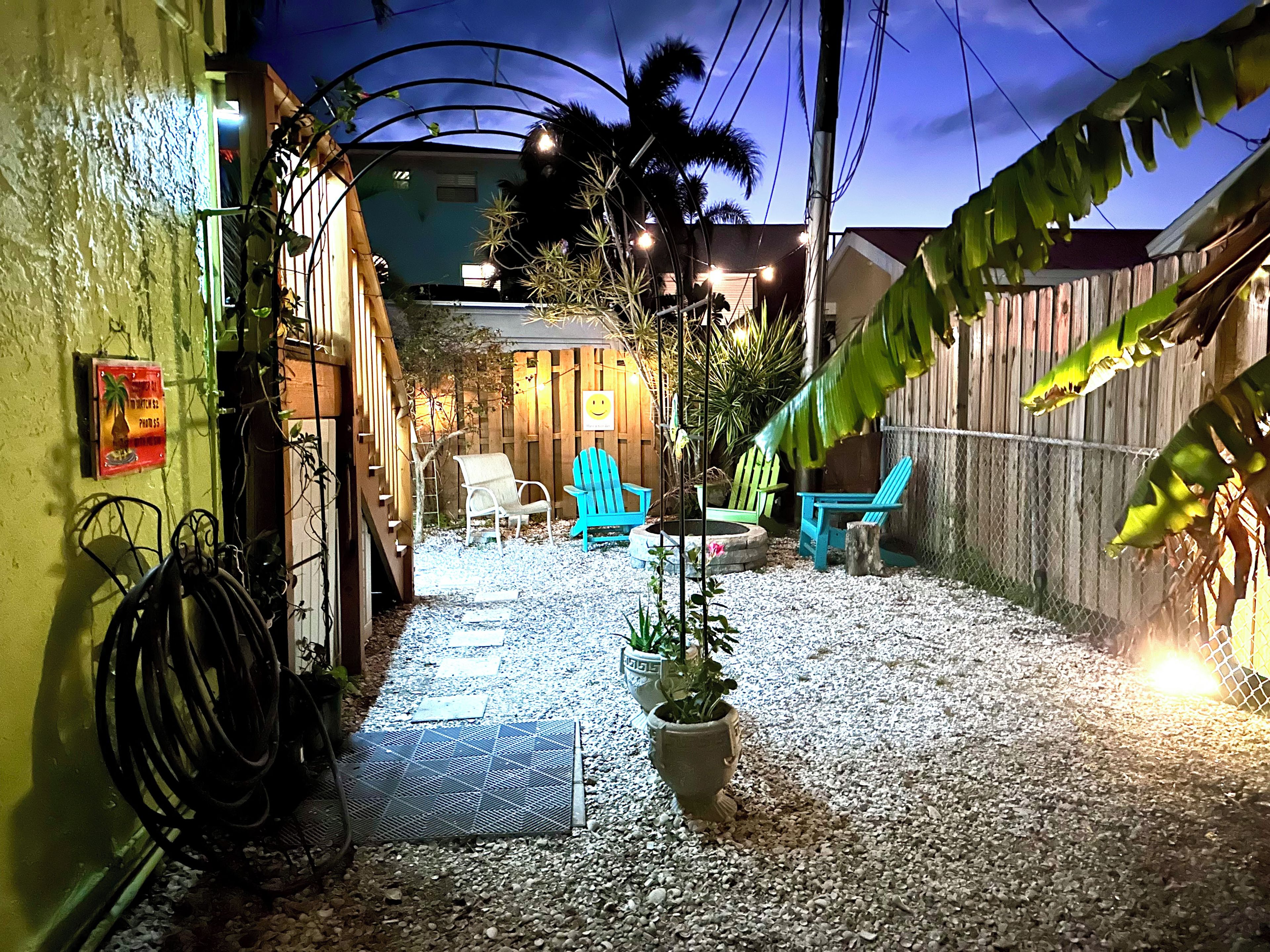 A patio area with outdoor seating and a pathway leading to a building entrance.