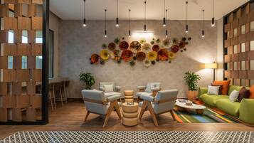 Una sala de estar moderna con un separador de madera, un comedor y un sofá verde.