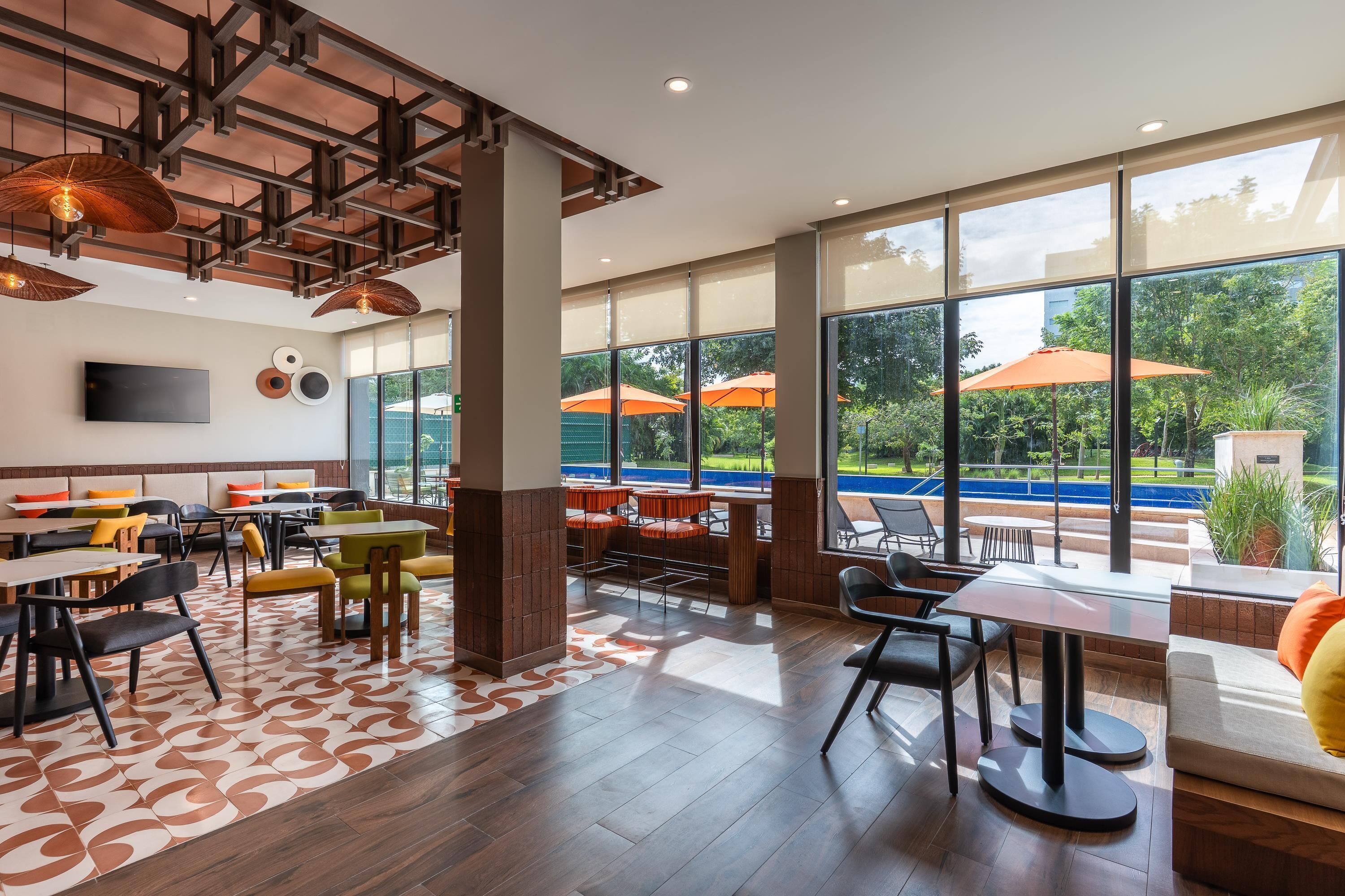 Un restaurante moderno con un amplio comedor, ventanas grandes y terraza con sombrillas.