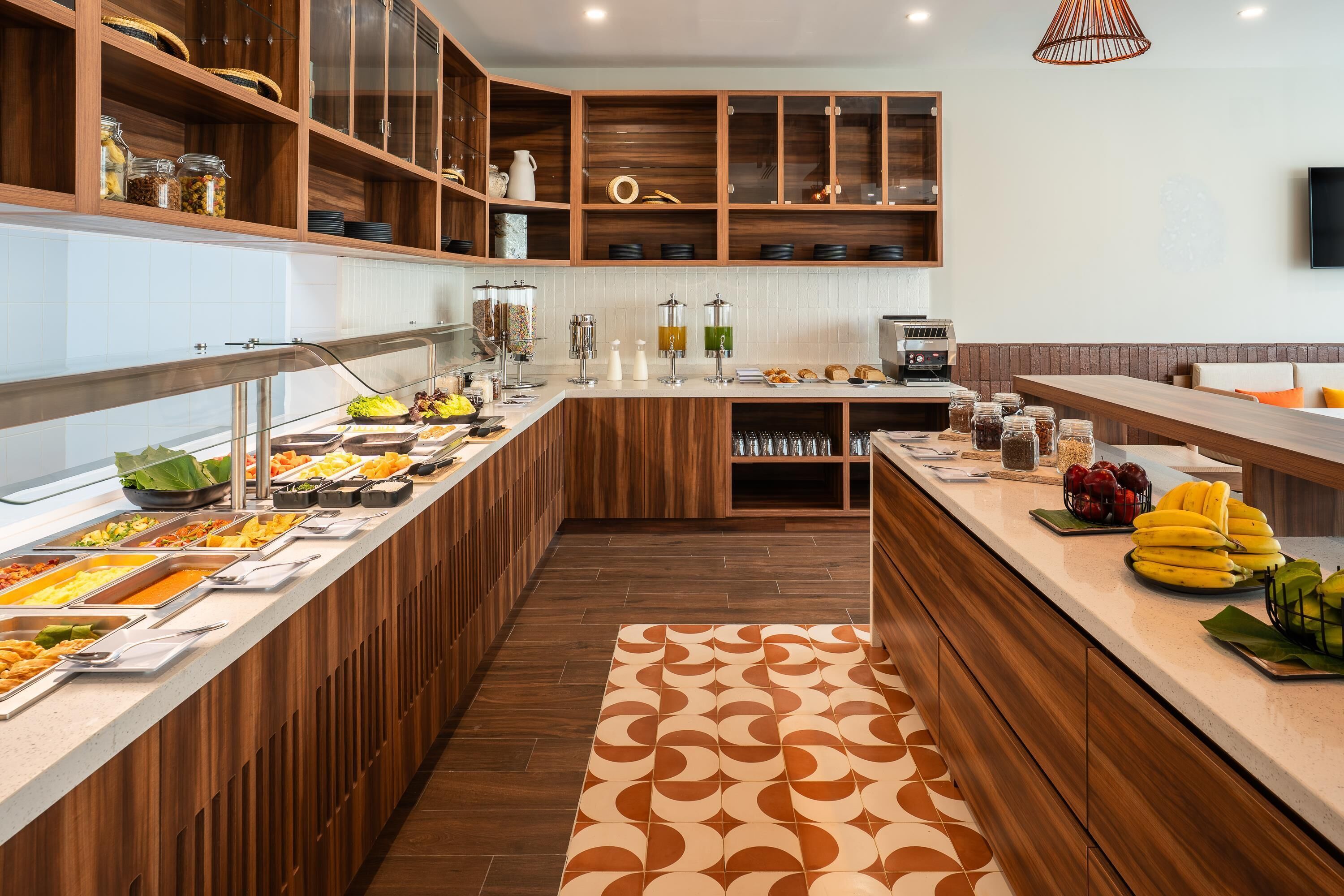 A buffet area with various food items, wooden cabinets, and a coffee machine.