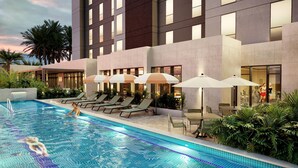 A modern hotel with a swimming pool, sun loungers, and umbrellas. - Hyatt Place Merida/Via Montejo (Mérida)