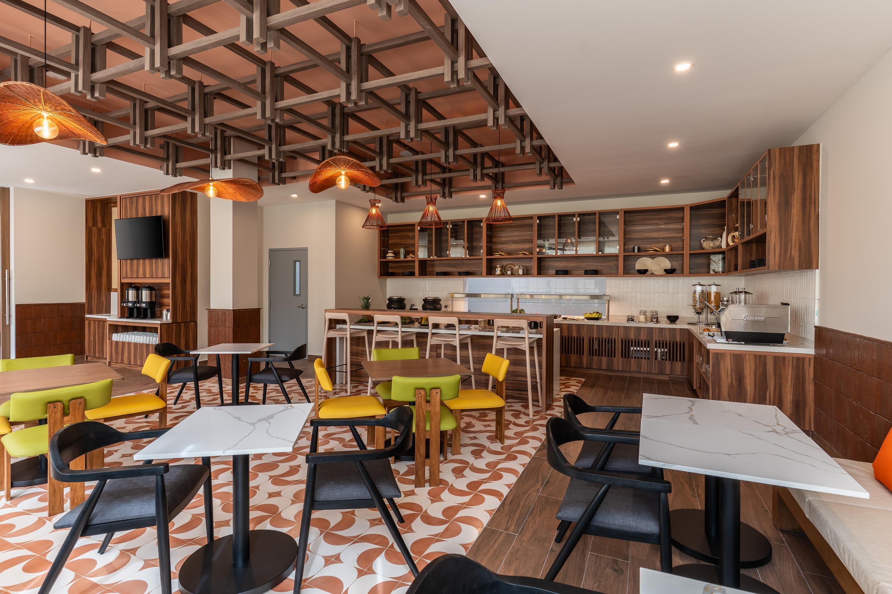 Un restaurante moderno con techos altos, vigas de madera y una zona central de comedor con mesas y sillas.
