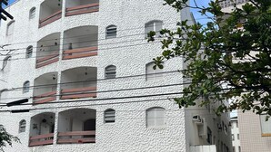 A multi-story building with balconies and a gated entrance.