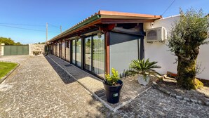 Un bâtiment doté d’une galerie couverte, de grandes fenêtres et d’un mur en pierre.
