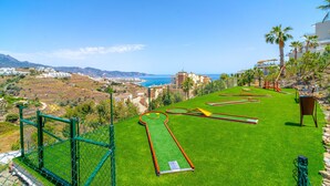Un campo de golf con vistas al mar y a las montañas.