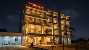 A multi-story hotel with a prominent sign reading "Omkara". - The Grand Omkara Hotel & Resorts (Khandwa)