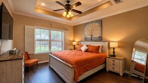 A bedroom with a bed, bedside tables, a desk, a chair, a ceiling fan, and a window. - Spacious 3BR Home • Sleeps 6 • Open Living • Private Yard (Victoria)
