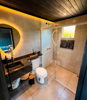 Un baño moderno con ducha, inodoro y zona de lavamanos.