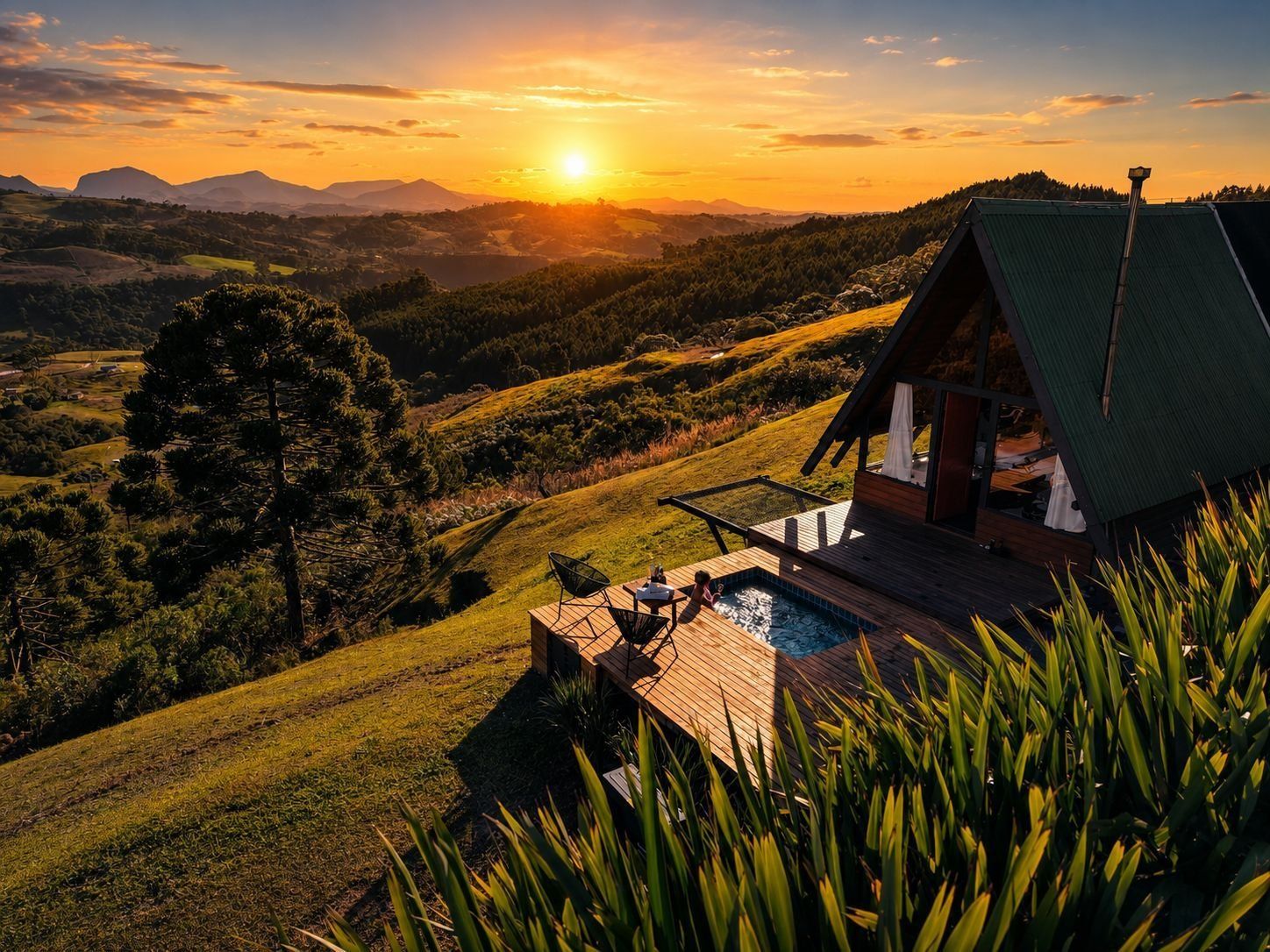 Una cabaña con piscina, rodeada de colinas y vista al atardecer.