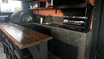 A kitchen with a wooden ceiling, a marble countertop, and a black stove.