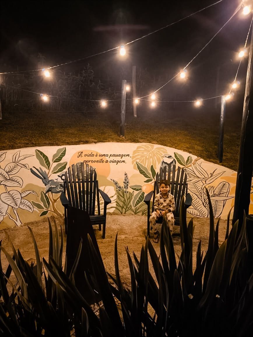 A circular outdoor seating area with chairs and a mural with text.