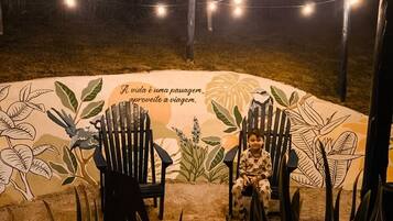 A circular outdoor seating area with chairs and a mural with text.
