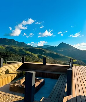 A wooden deck with a hot tub and a view of mountains. - Refugio mirante da montanha (Alfredo Wagner)