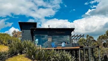 Een moderne chalet met terras, grote ramen en een pergola.