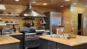 Una cocina moderna con paredes de madera, una isla central y electrodomésticos integrados.