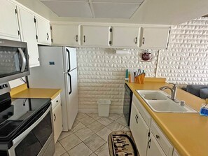 A compact kitchen with white cabinets, a microwave, a refrigerator, a sink, and a coffee machine. - Waterfront Getaway - Tahoe Keys Townhome (South Lake Tahoe)