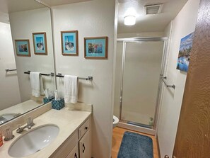 A bathroom with a sink, mirror, towel rack, and framed pictures on the wall. - Waterfront Getaway - Tahoe Keys Townhome (South Lake Tahoe)