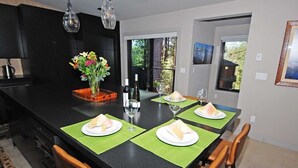 A modern kitchen with a central island, dining table, and chairs. - Penthouse Retreat with Mountain Views & Designer Touches (South Lake Tahoe)
