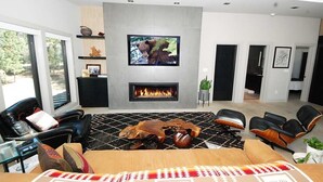 A modern living room with a fireplace, a mounted TV, and comfortable seating. - Penthouse Retreat with Mountain Views & Designer Touches (South Lake Tahoe)