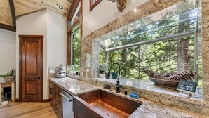 Une cuisine dotée d’une grande fenêtre, de meubles en bois et d’un plan de travail en granit.