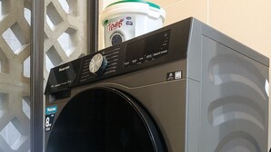 A front-loading washing machine with a control panel and a detergent container on top. - Nova Stays 1-Bedroom Apartment with Private Pool & Uninterrupted Seaview (Mombasa)