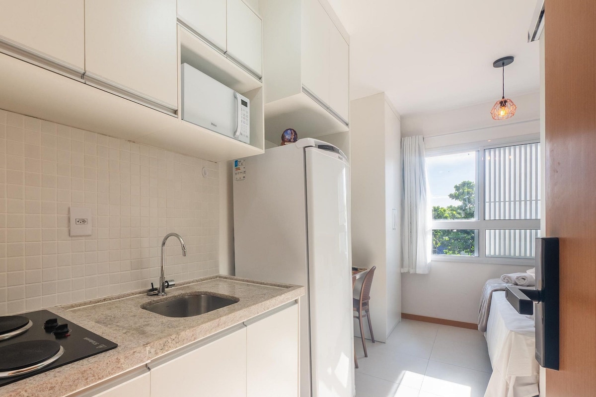 A modern kitchen with white cabinets, a built-in microwave, a stainless steel sink, and a double oven.
