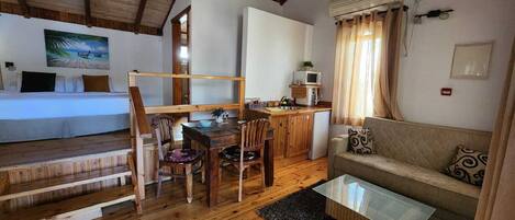 Acogedor interior de cabaña con una mesa de comedor de madera, un sofá y una zona de cocina.