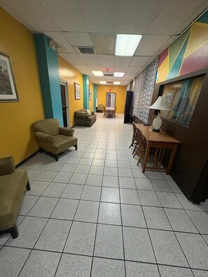 Eine Hotelhalle mit Essbereich, Sofas und einer Wand mit Muster.