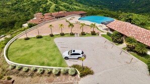 Ein Resort mit Schwimmbad, Parkplatz und Blick auf die umliegende Landschaft.