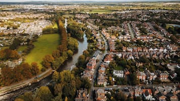 An aerial view of a residential area with houses, a river, and a park.