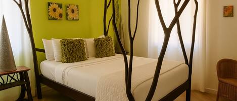 A bed with a tree-like canopy structure, a green wall, and a wicker chair.