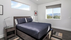 A bedroom with a bed, nightstands, a desk lamp, a window with a view, and a ceiling fan. - Exceptional Vacation Home - 1 bdr in Torrey, UT near Capital Reef National Park (Torrey)
