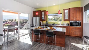 A modern kitchen with a central island, wooden cabinets, and a view of the outdoors. - Exceptional Vacation Home - 1 bdr in Torrey, UT near Capital Reef National Park (Torrey)
