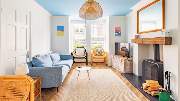 A living room with a sofa, chairs, a fireplace, and a large window. - Gorleston Beach House by Leap Escapes (Gorleston-on-Sea)