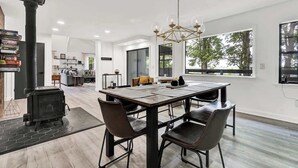 Een moderne keuken met een centraal eiland, een ingebouwde kookplaat en grote ramen.