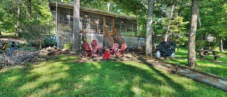 A house with a covered porch, a wooden deck, and a picnic table.