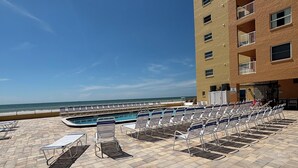 Een zwembad op het dak met ligbedden en een zwembad, met uitzicht op de oceaan.